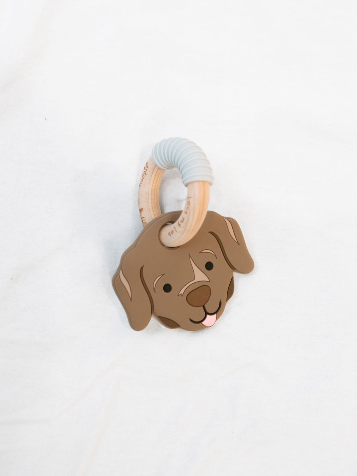 Silicone Chocolate lab teether on birch wood ring on a white background