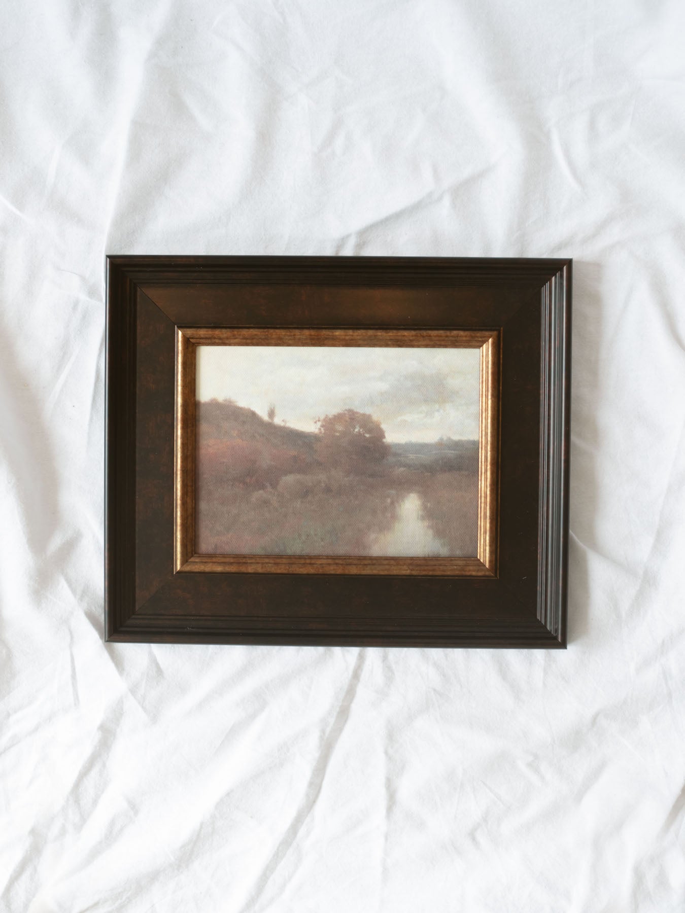 A tranquil landscape artwork featuring a winding stream flowing through a peaceful autumn marsh. Soft earthy tones, atmospheric skies, and painterly details capture the quiet beauty of the countryside, creating a timeless accent for any space.