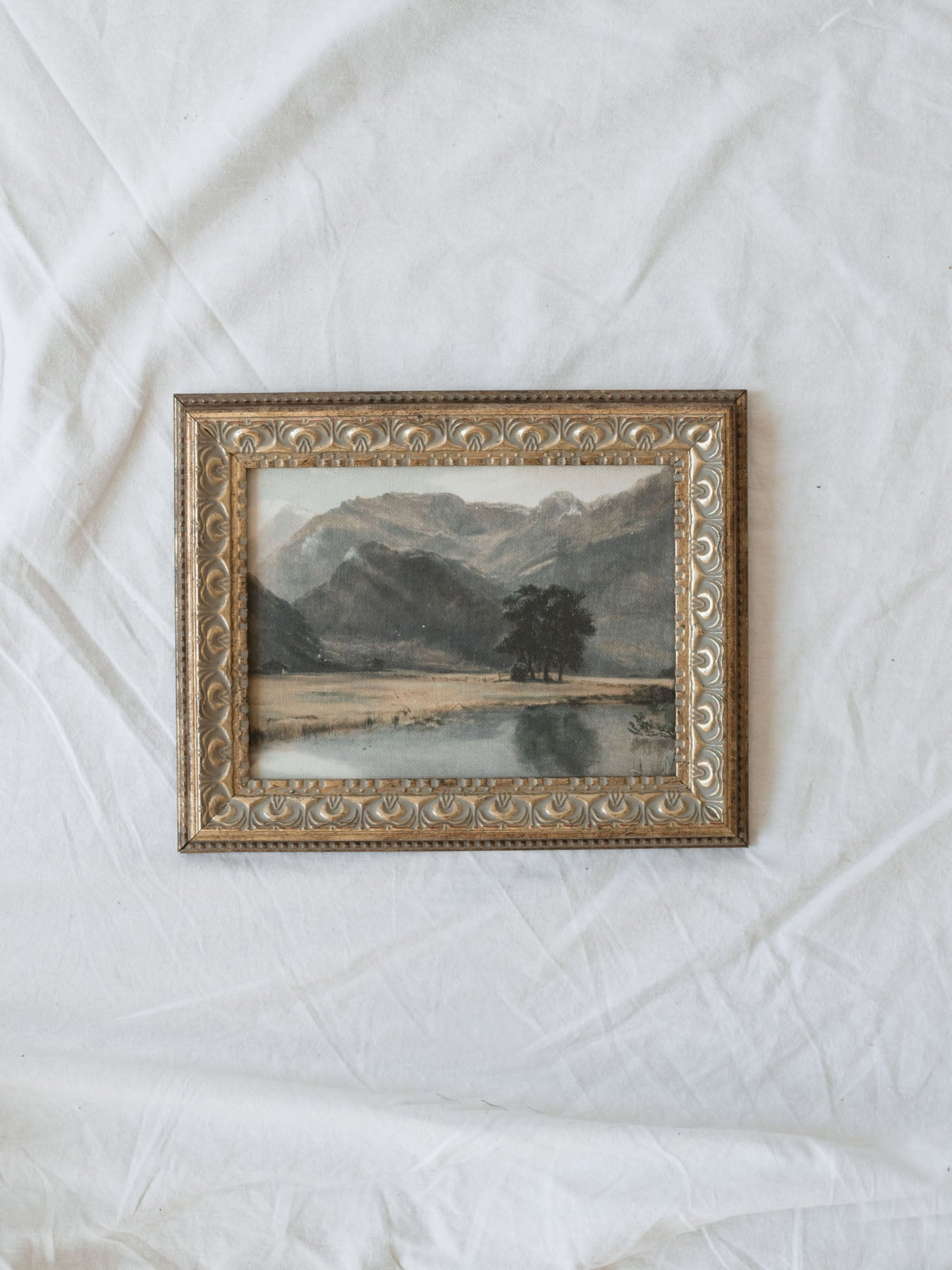 A breathtaking mountain landscape featuring rugged peaks, a tranquil reflective pond, and an open valley bathed in soft natural light. This timeless scene captures the grandeur and serenity of the wilderness.