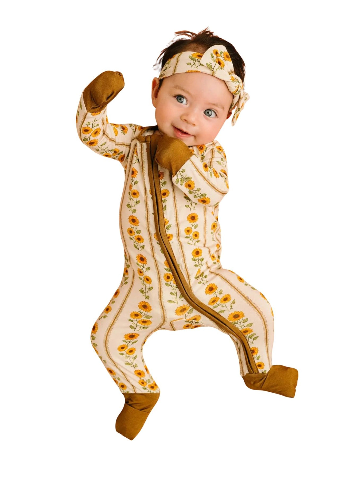 little baby wearing a bamboo sleeper with sunflower and mustard detail on a white background