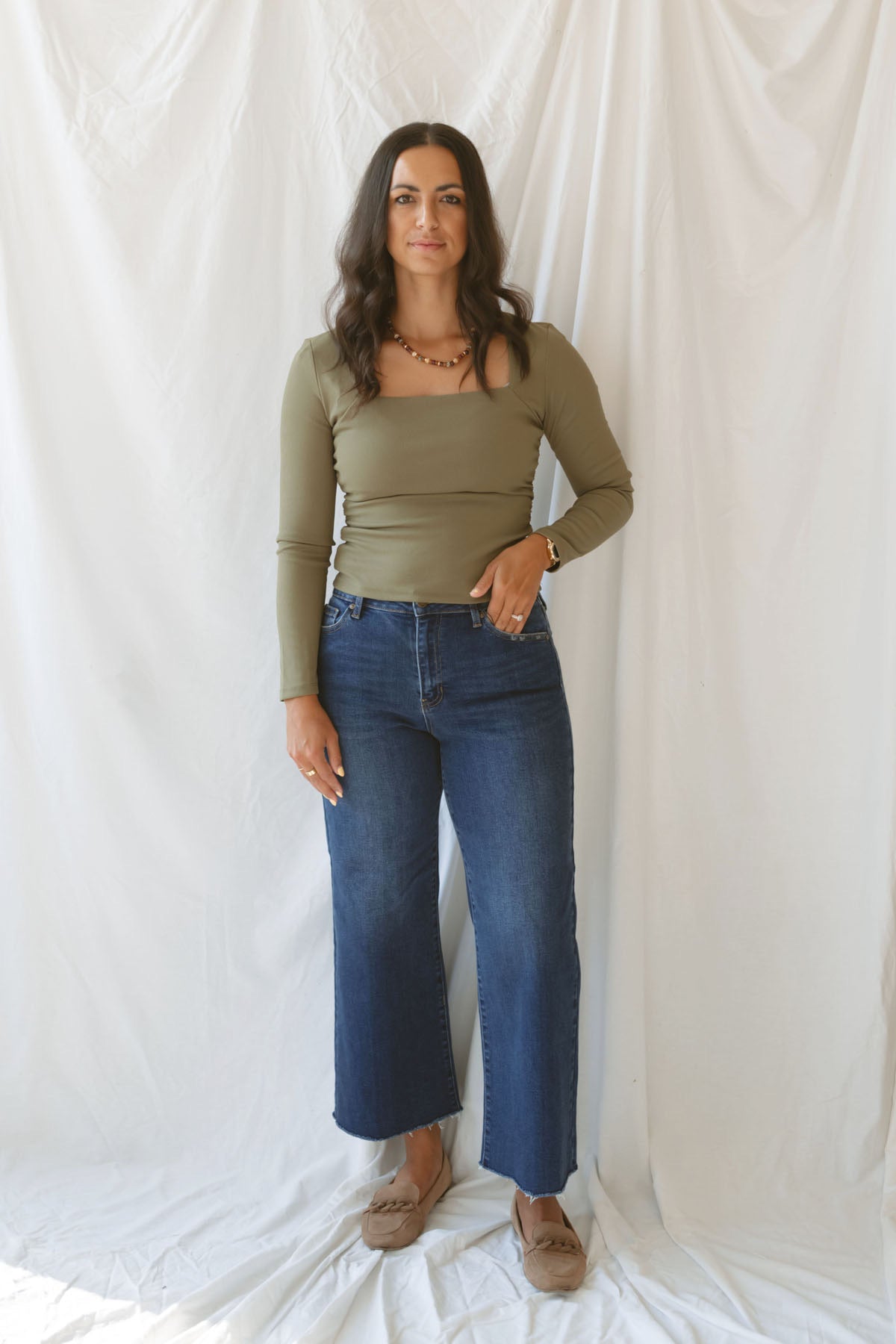 Model wearing the square neck long sleeve ruched side top in olive.