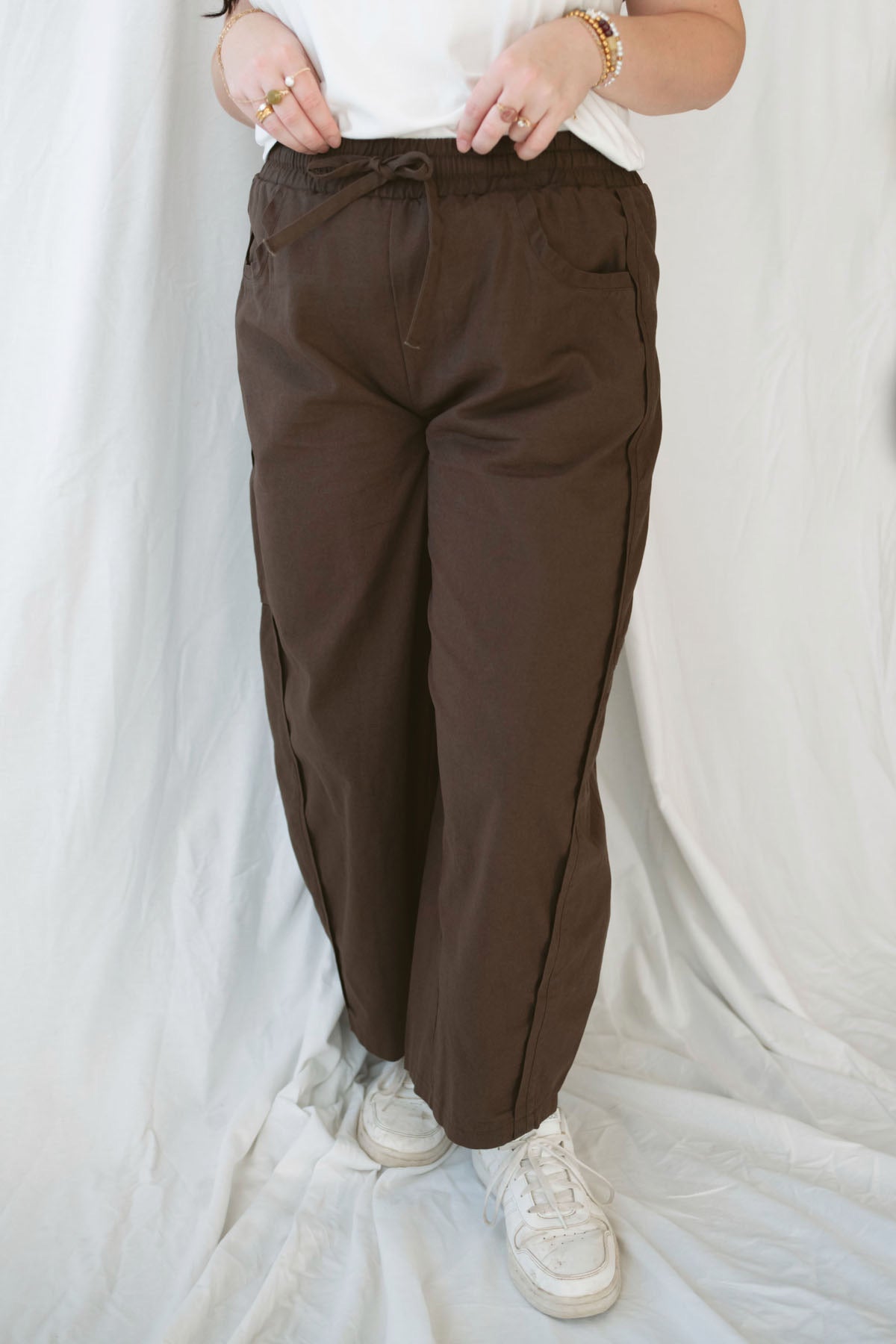 Model wearing the drawstring barrel style pant in coffee bean brown.
