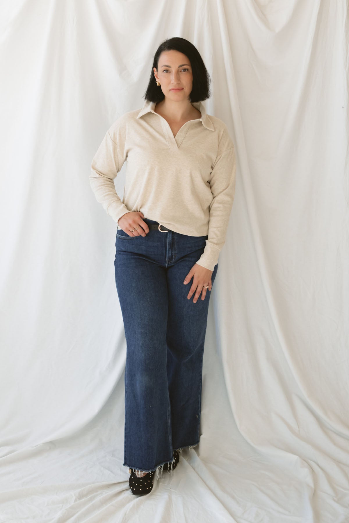 Model is wearing the knit polo sweater in the color beige.