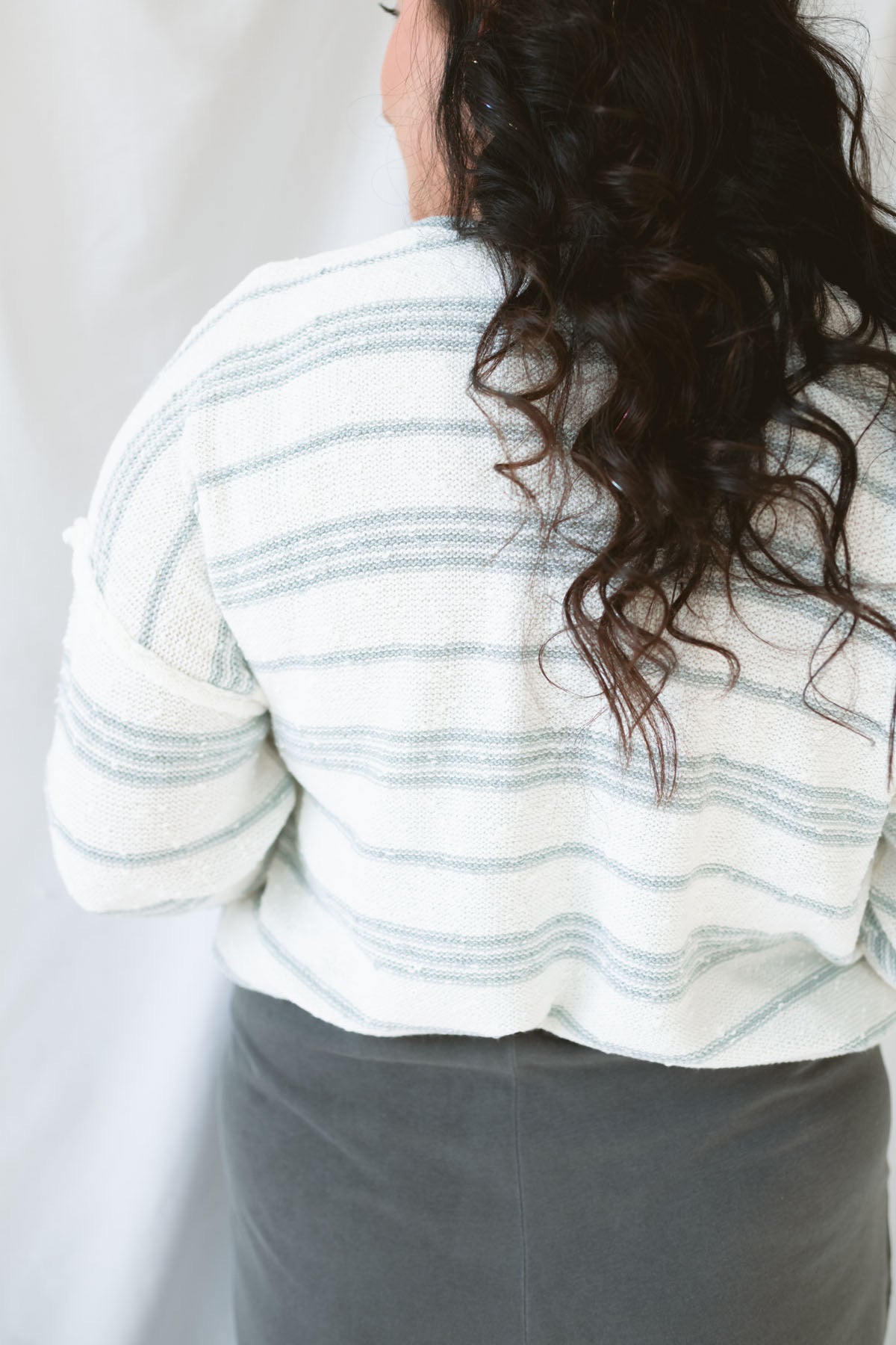 Model wearing the textured striped oversized sweater. Lightweight enough to wear now and into the next season. Paired with the Mila wide leg pants, this outfit is comfy, casual, and still put together.