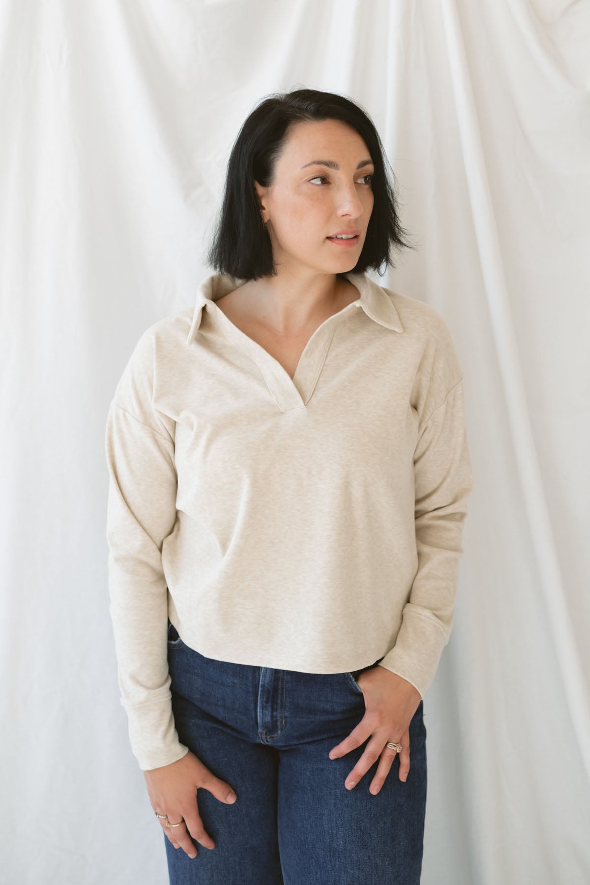 Model is wearing the knit polo sweater in the color beige.