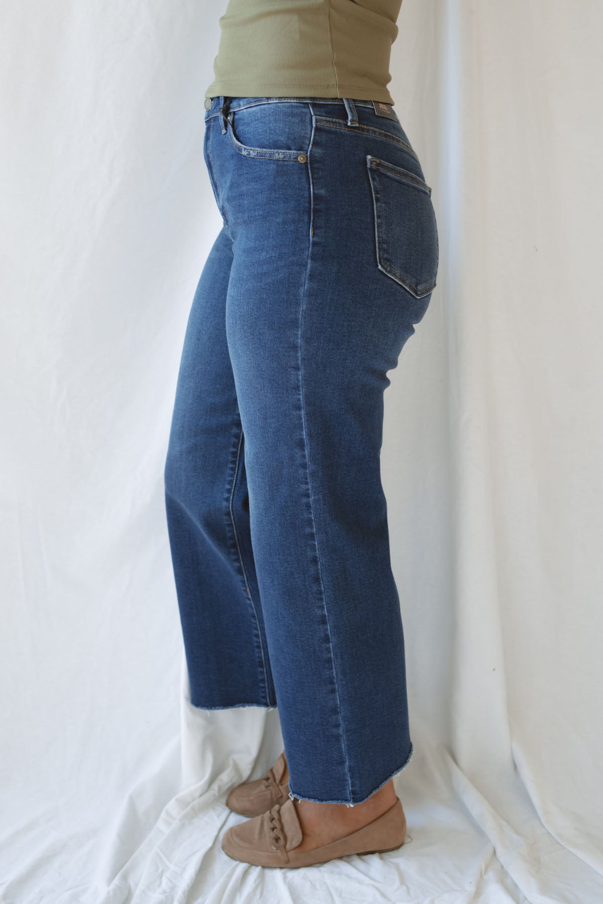 Model wearing the scissor cut slim denim in a dark wash. Great length to wear with a pointed toe boot or sneaker. Can easily be dressed up or down.