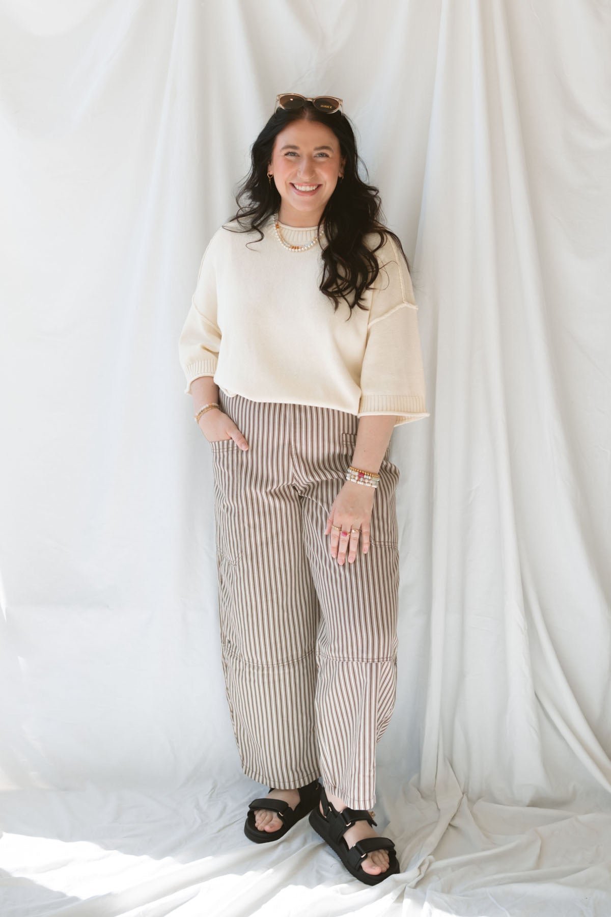 Model wearing the drop sleeve exposed seam sweater short sleeve top. This top is very versatile, styling it during warm months with shorts of any kind and in the cooler months with long pants and eventually layering under jackets and blazers.