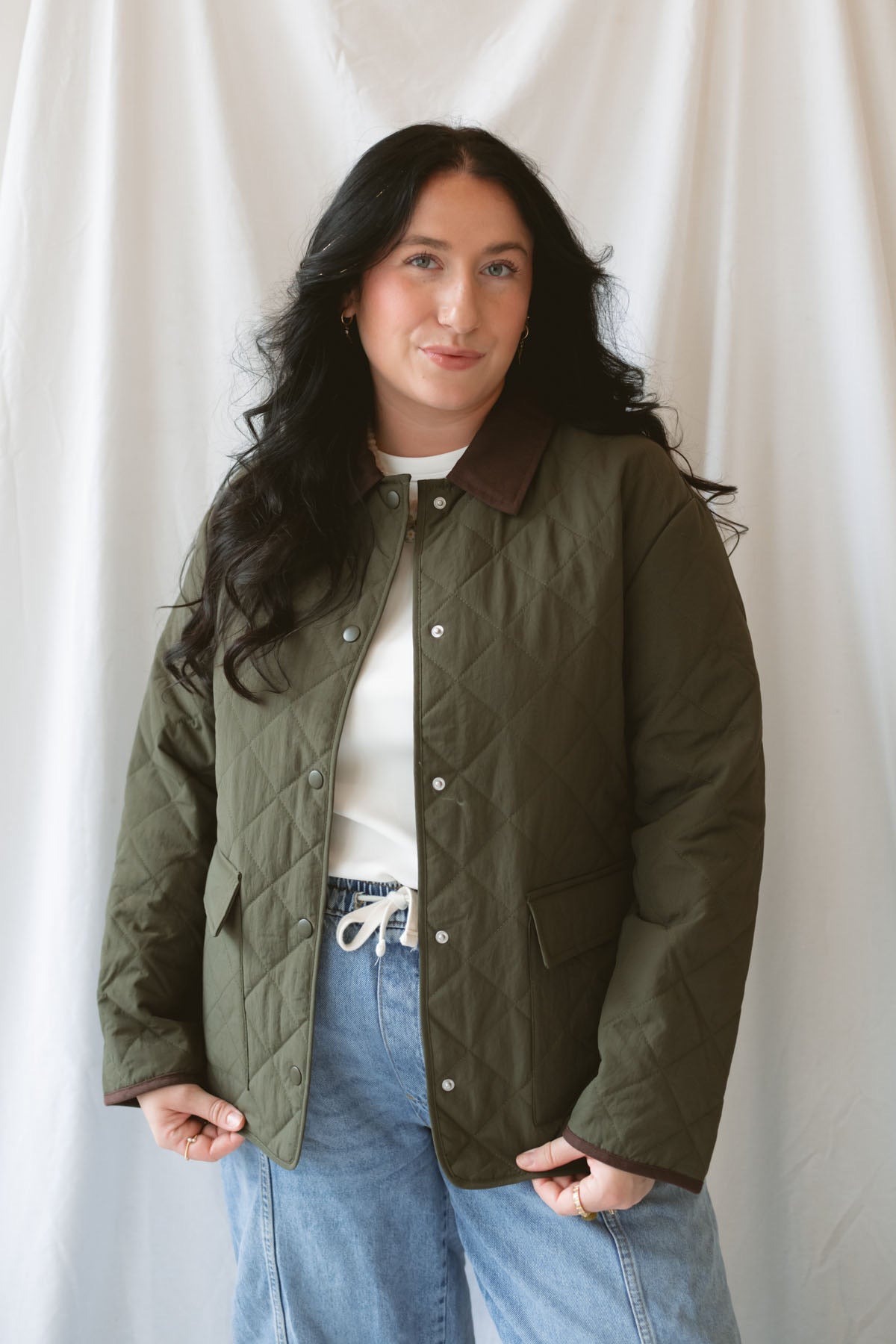 Model is wearing the lapel collar quilted jacket in olive.