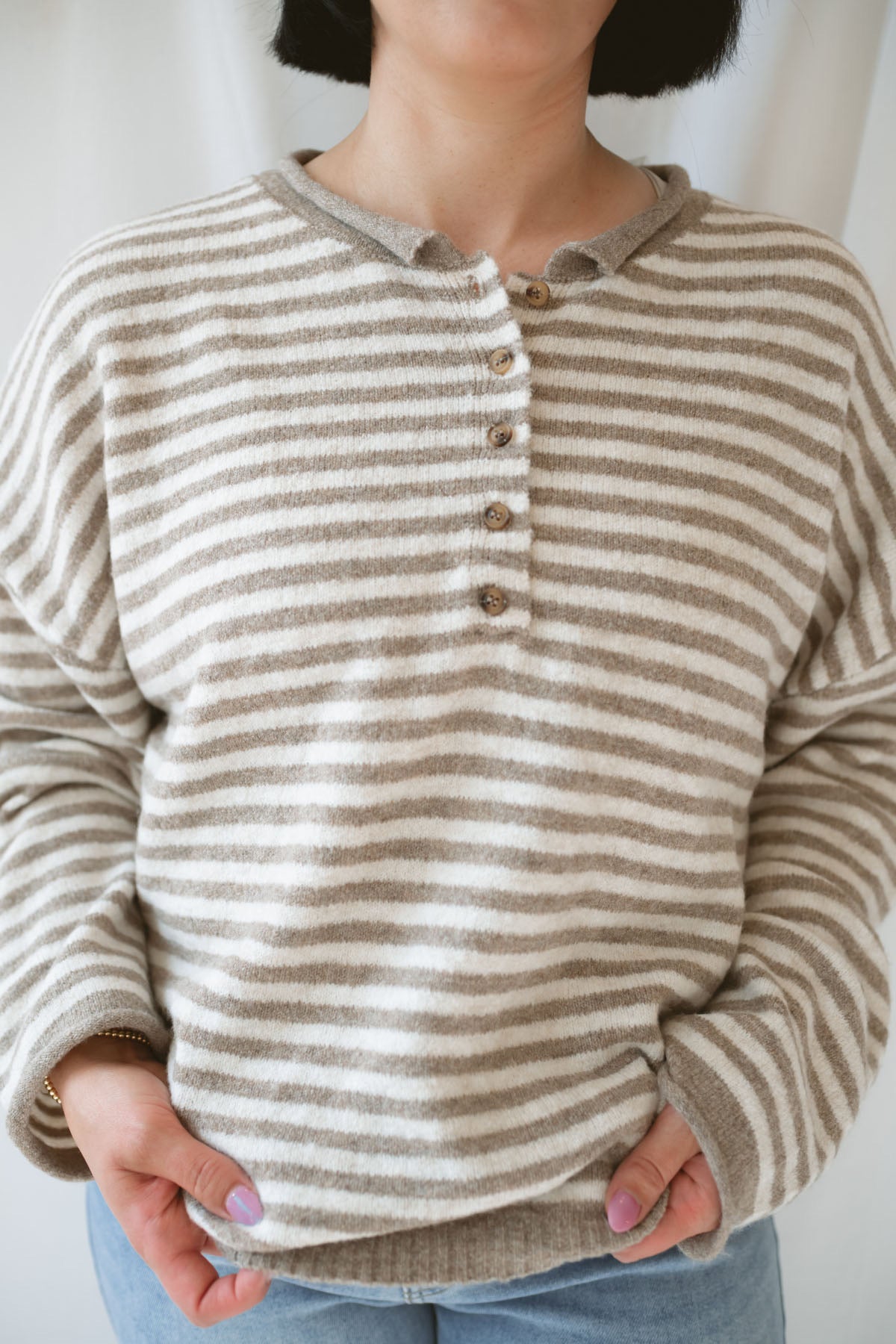 Model wearing the Quinn henley striped long sleeve sweater.