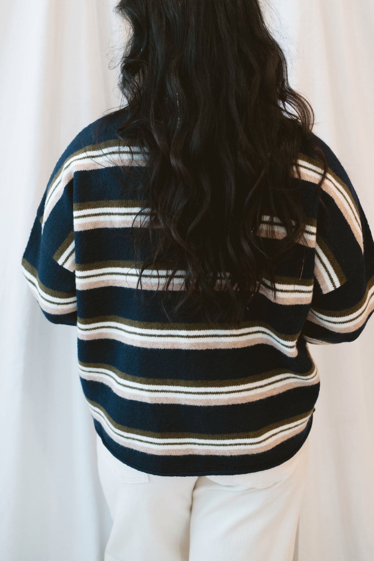 Model wearing navy stripe and multi colored button up cardigan.