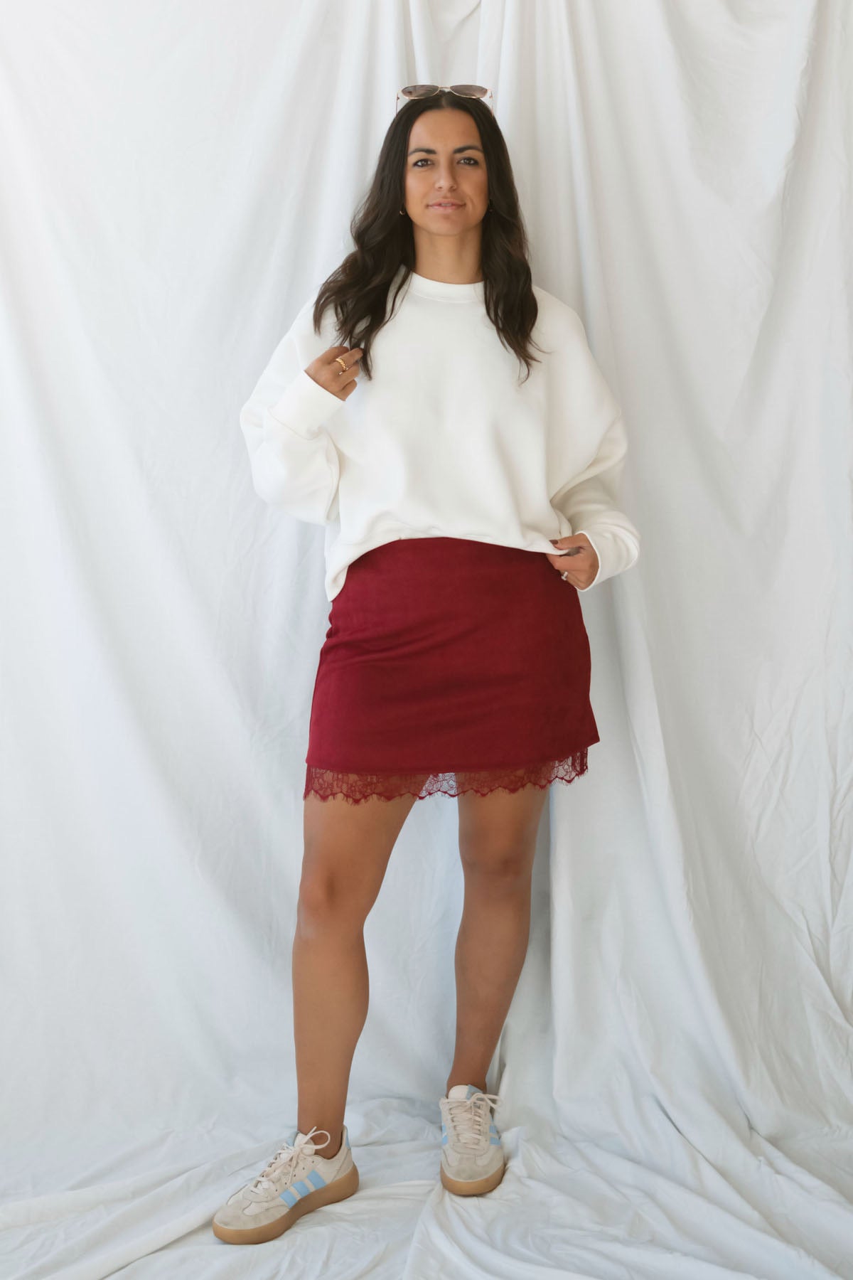 Model wearing suede mini skirt with lace trim detail.