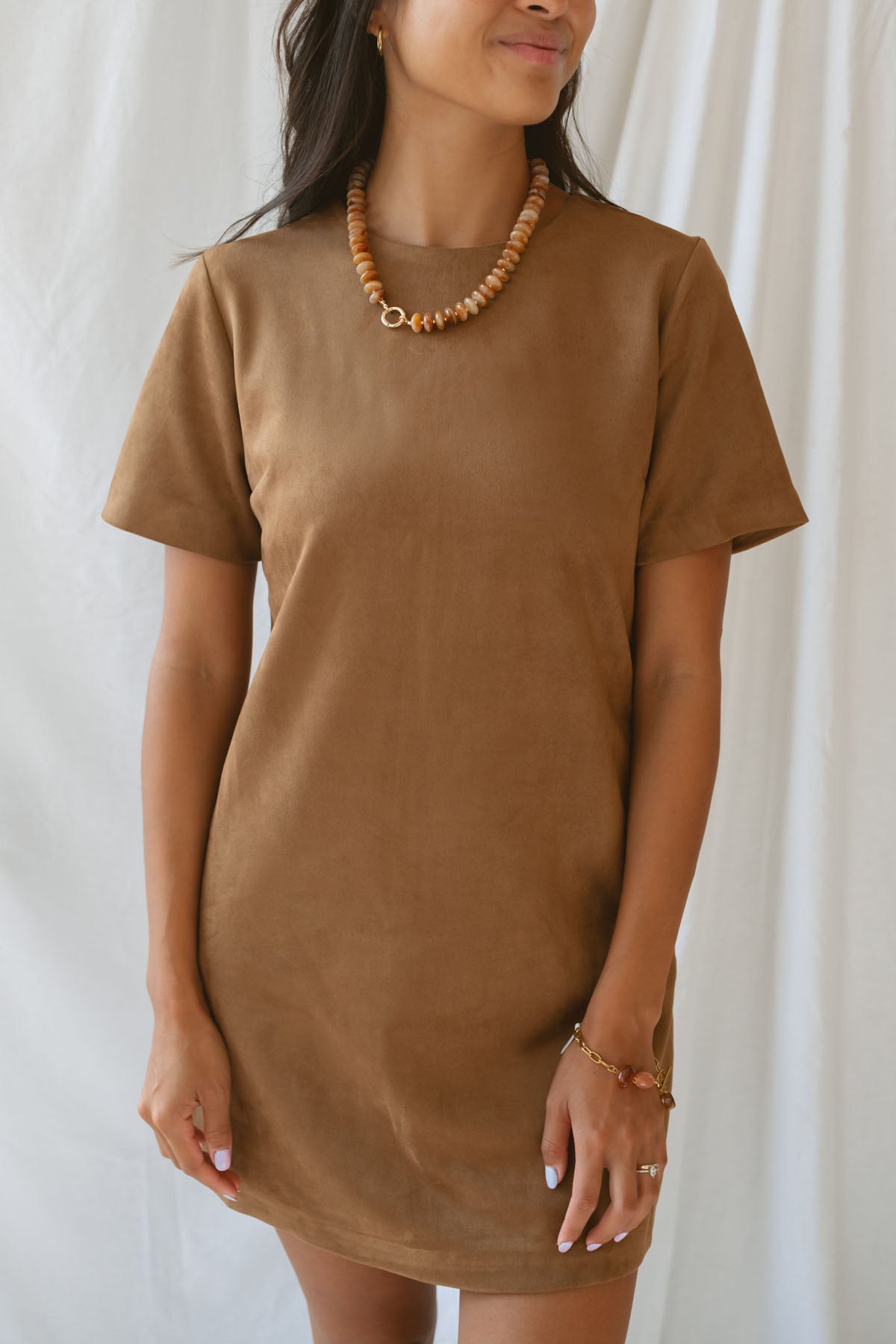 Model wearing the faux suede mini t-shirt style dress. A casual option that can be dressed up with boots and jewelry.