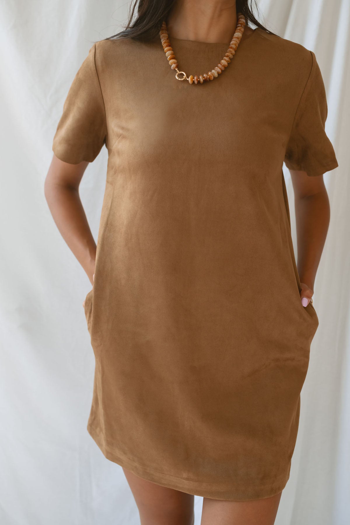 Model wearing the faux suede mini t-shirt style dress. A casual option that can be dressed up with boots and jewelry.