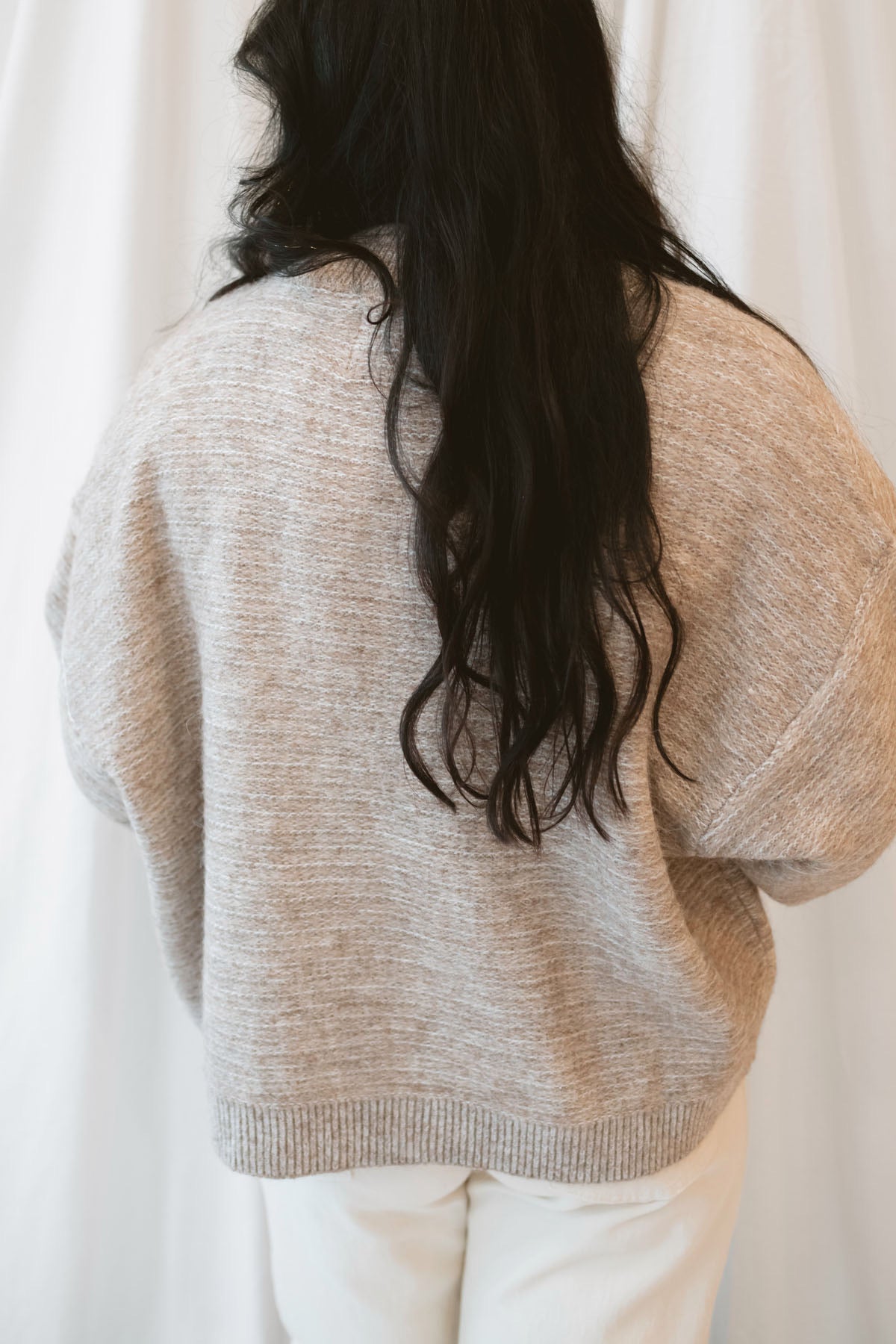 Model wearing boxy fit button up cardigan in latte tan.