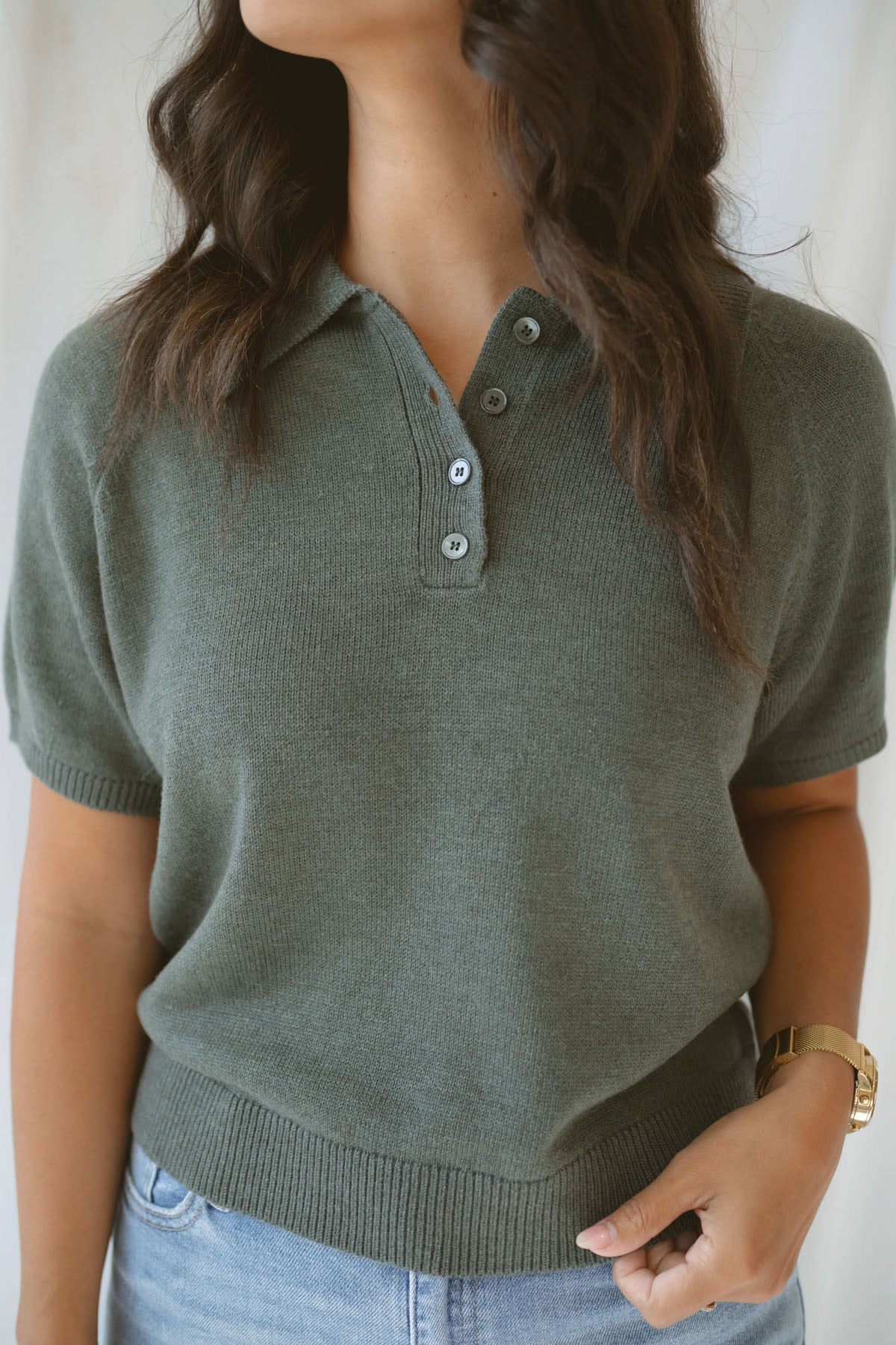 Close up view of model wearing the short sleeve polo sweater. A soft and polished option for a put together outfit.