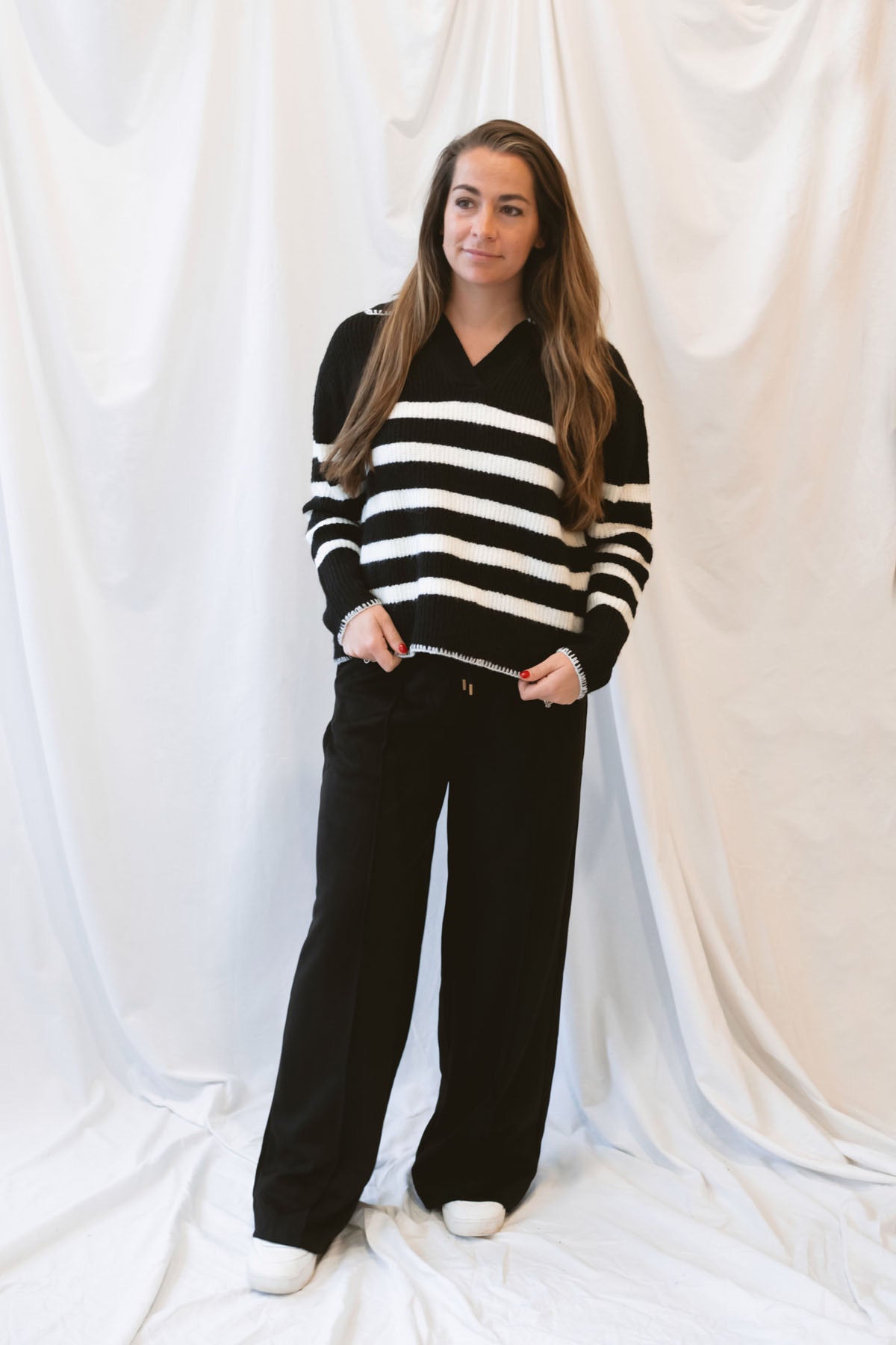 Black striped knit sweater top for women featuring a collared V-neckline, contrasting trim, and classic preppy-inspired design for elevated everyday styling.