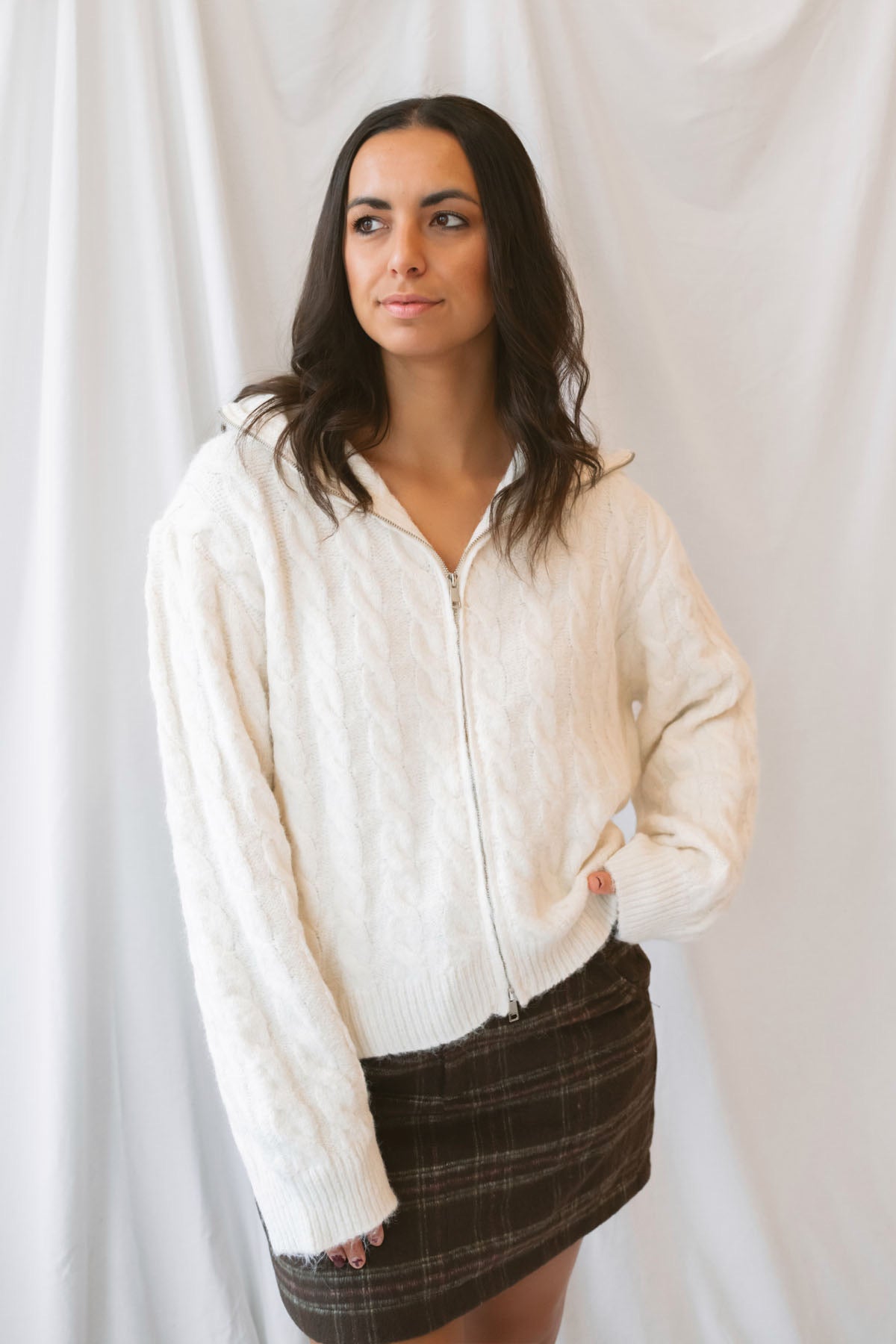 Madison High Neck Cable Fuzzy Knit Zip Up Cardigan in Cream featuring a high neckline, textured cable knit pattern, and zip-front closure.