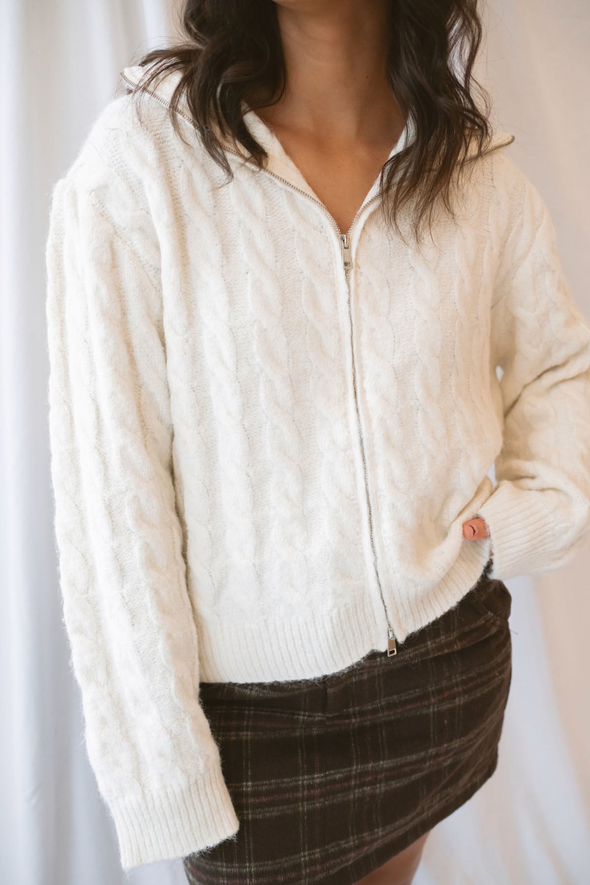 Madison High Neck Cable Fuzzy Knit Zip Up Cardigan in Cream featuring a high neckline, textured cable knit pattern, and zip-front closure.