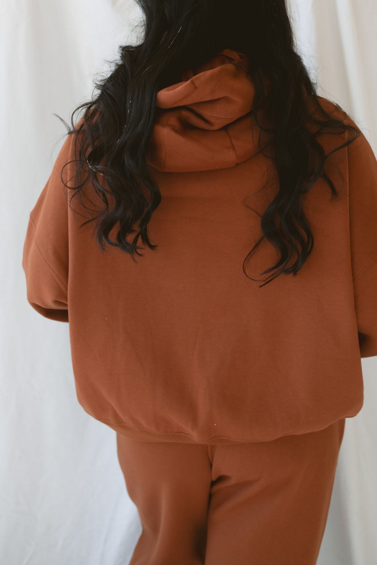 Model is wearing the oversized rust colored hoodie sweatshirt.