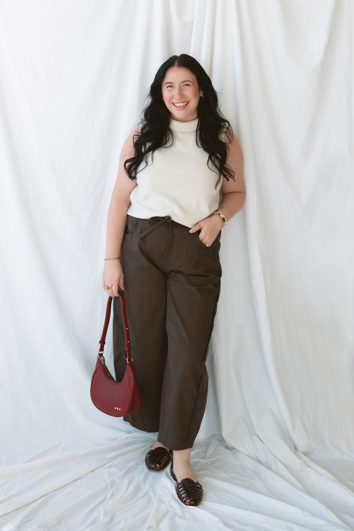 Model wearing sleeveless beige turtleneck.
