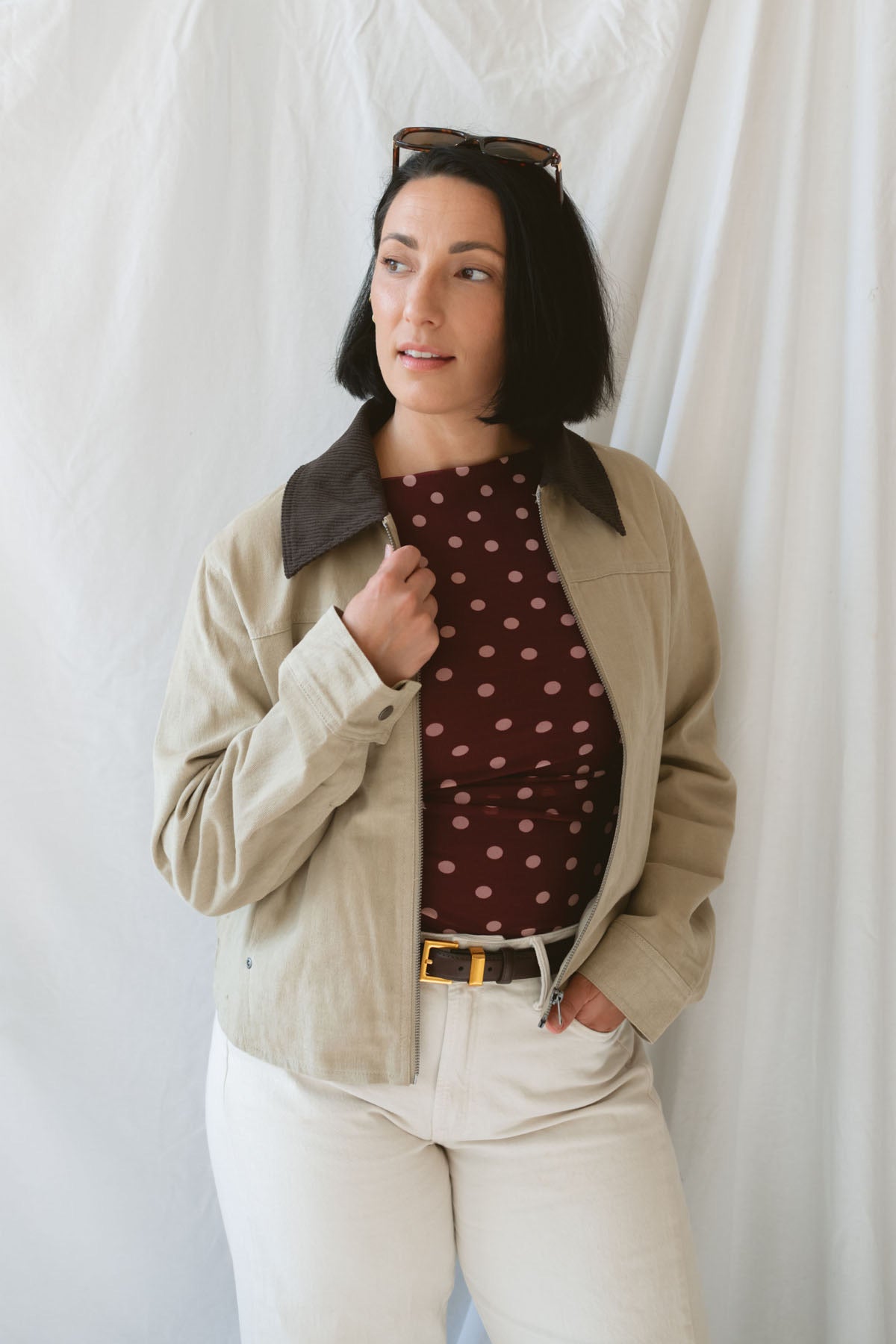 Model wearing the contrast corduroy collar zip up bomber jacket over the rynlee polka dot mesh tank in burgundy. The jacket is a great lightweight layer for cooler months.