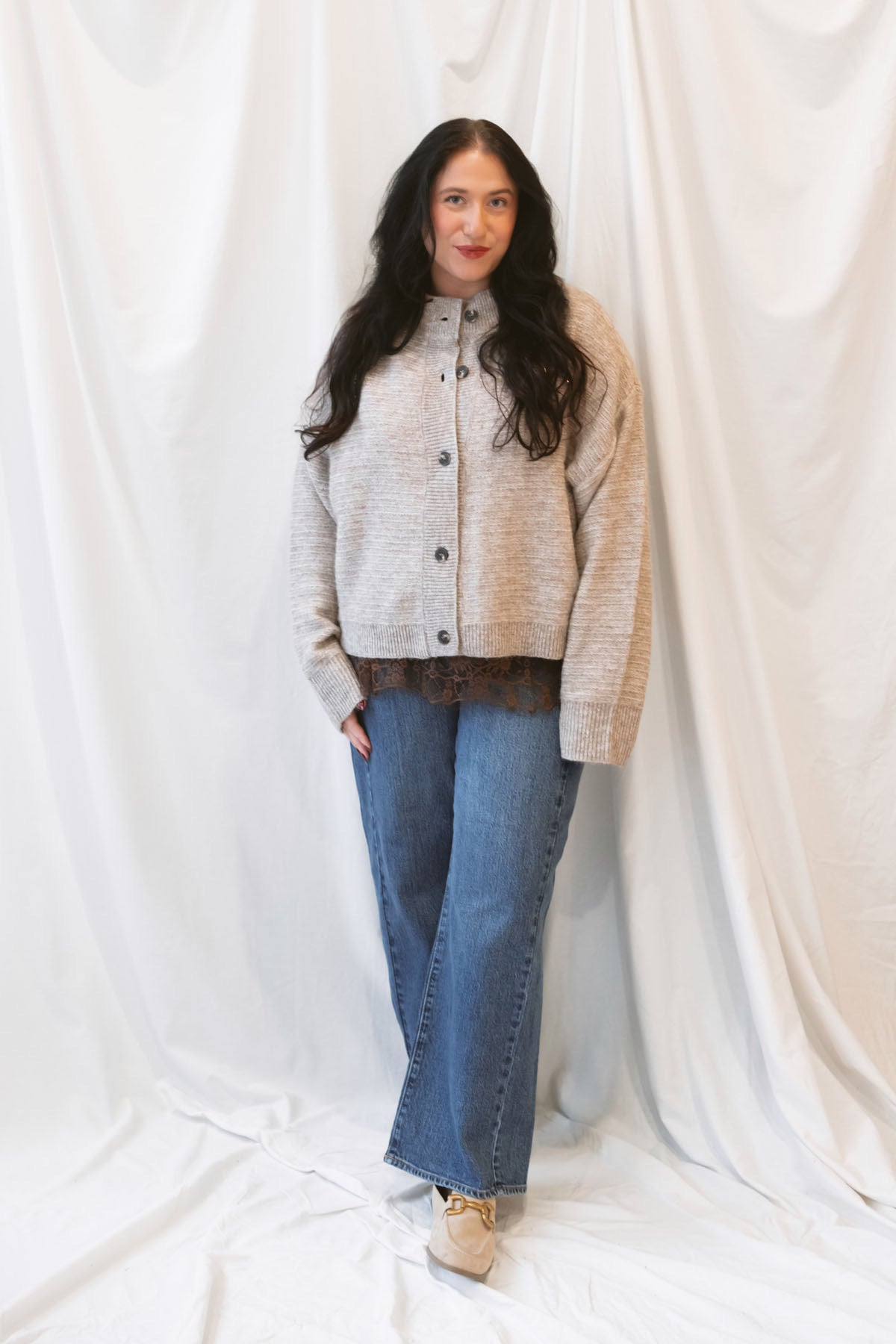 Model wearing boxy fit button up cardigan in latte tan.