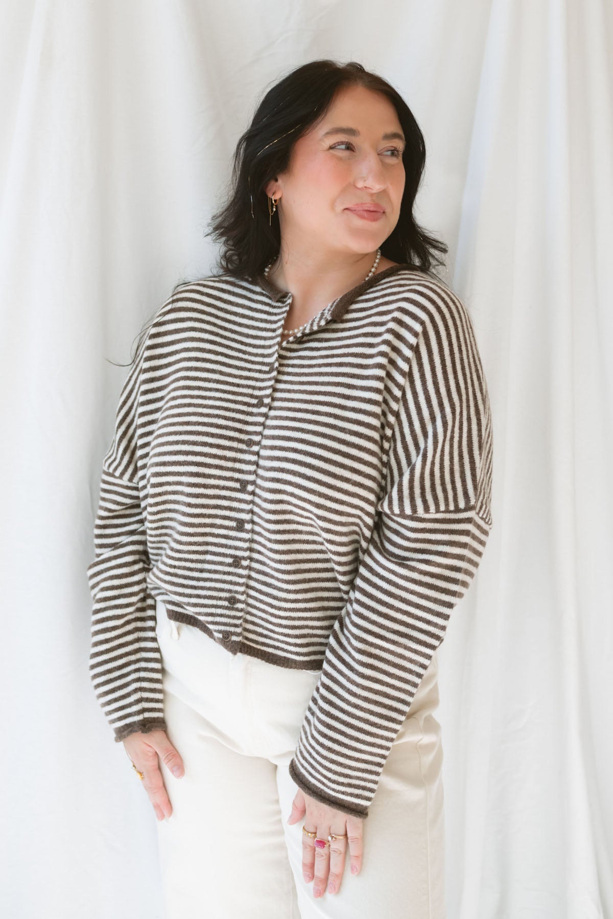 Close up view of model wearing the stripe drop shoulder long sleeve cardigan. This cardigan layers well over many tanks and shirts or you can wear it fully buttoned up as a top. Easy to transition form season to season.