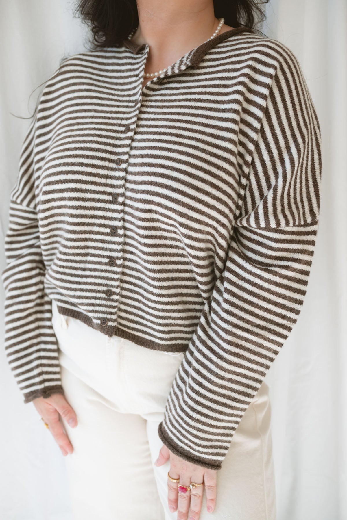 Close up view of model wearing the stripe drop shoulder long sleeve cardigan. This cardigan layers well over many tanks and shirts or you can wear it fully buttoned up as a top. Easy to transition form season to season.