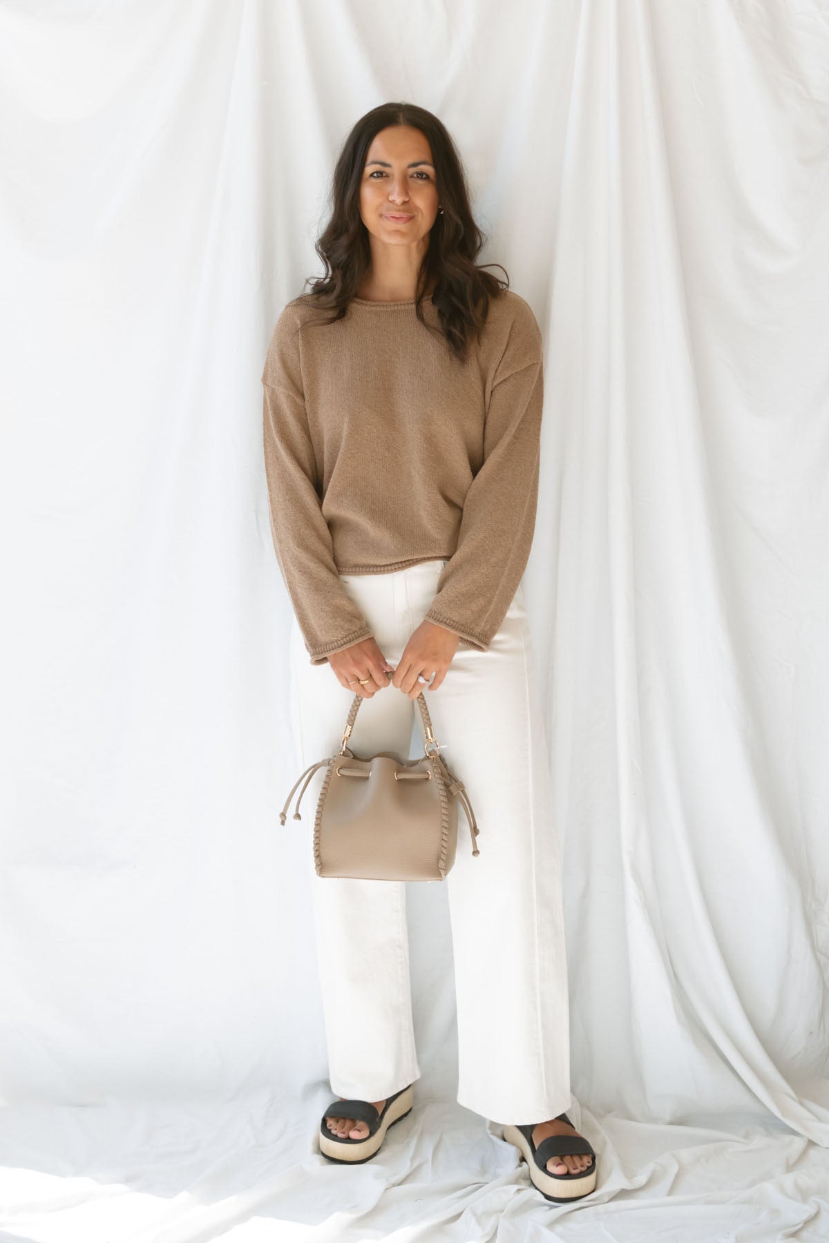 Model wearing long sleeve raw edge knit sweater. Paired with shorts during the summer or pants heading into the cooler seasons makes this a great staple season after season.