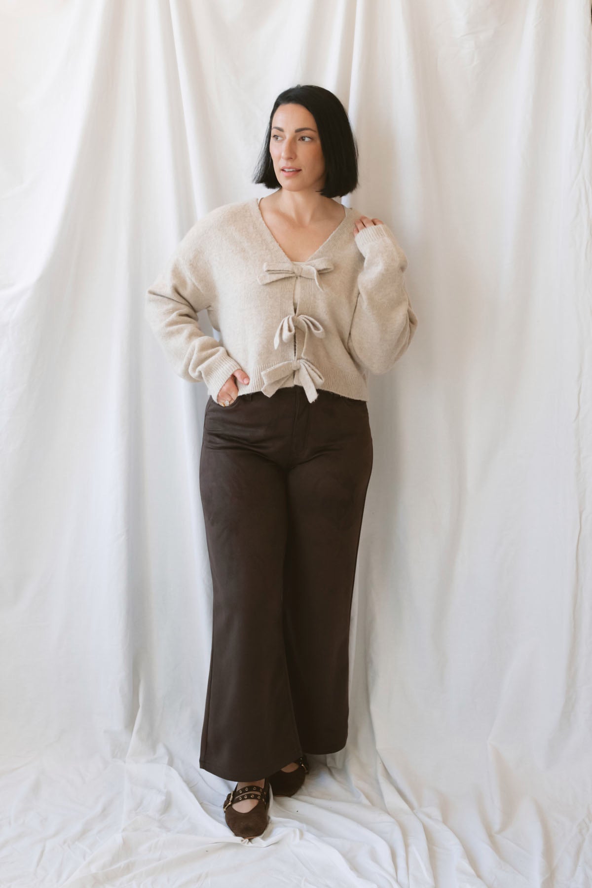 Kayla light taupe knit sweater with a reversible ribbon bow detail, styled with the bow in front.