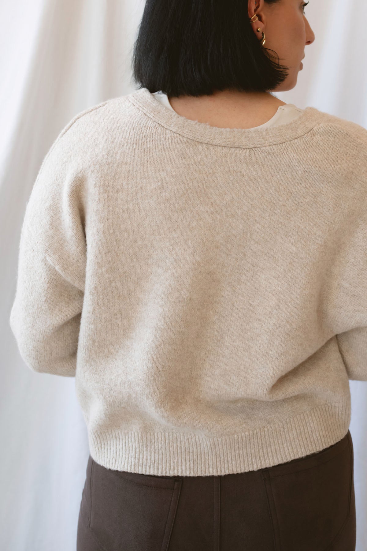 Kayla light taupe knit sweater with a reversible ribbon bow detail, styled with the bow in front.