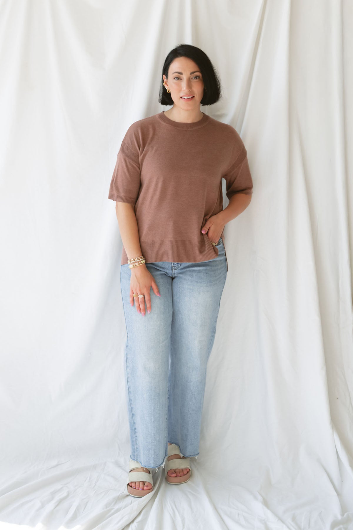 Model wearing the boxy fit short sleeve sweater in a rusty rose / sepia color. Model paired the top with jeans and a platform sandal. Wears well through seasons.