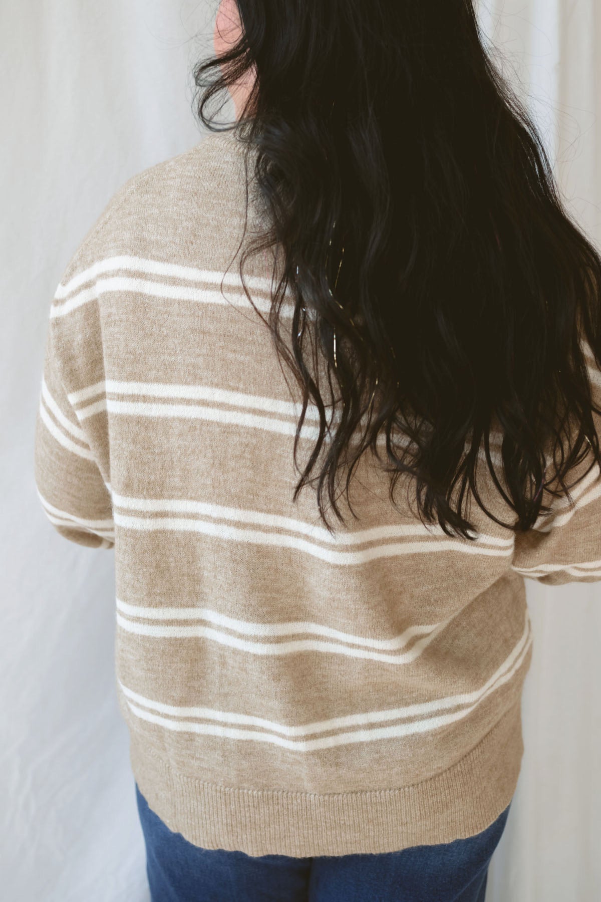 Model wearing the stripe drop sleeve crew neck sweater in mocha. This is perfectly oversized and great to pair with a variety of pants.