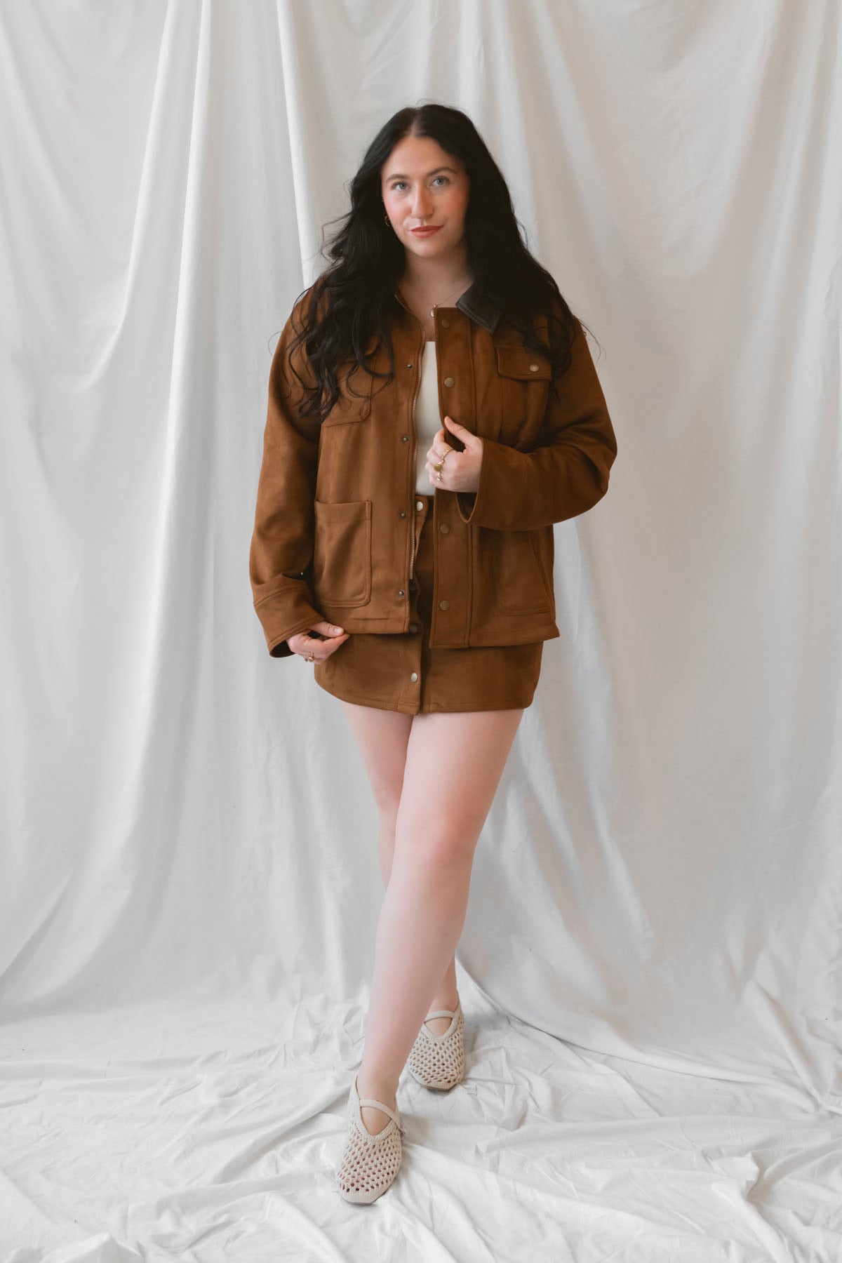 Ava Snap Front Suede Mini Skirt in cognac featuring a warm brown suede-style finish and snap-front detailing.