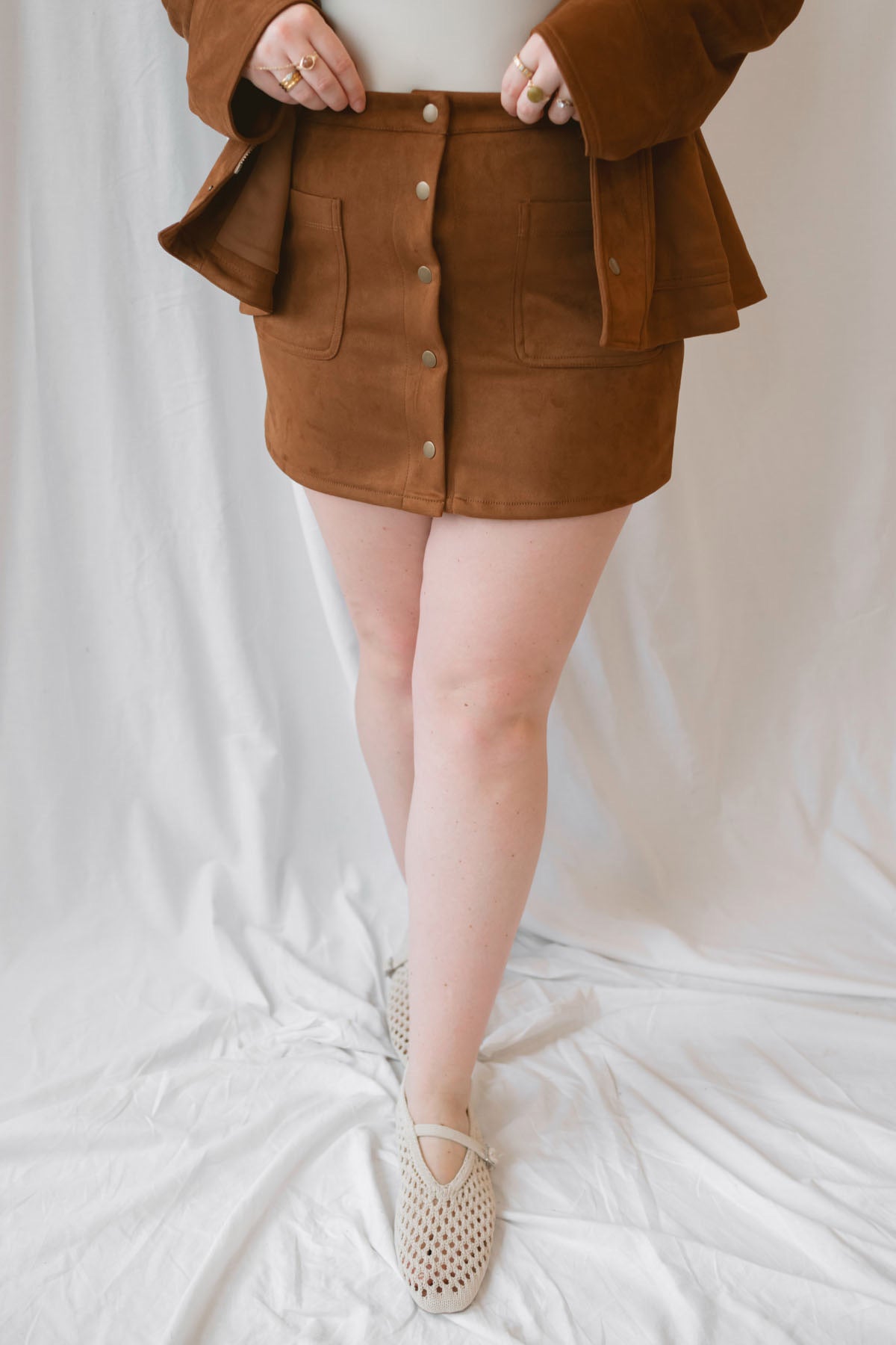Ava Snap Front Suede Mini Skirt in cognac featuring a warm brown suede-style finish and snap-front detailing.