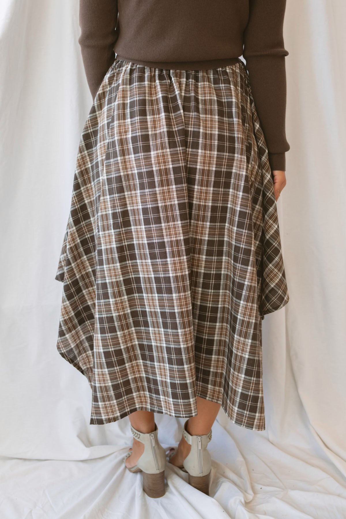 Riley brown plaid midi skirt with an asymmetrical hem and classic autumn pattern.