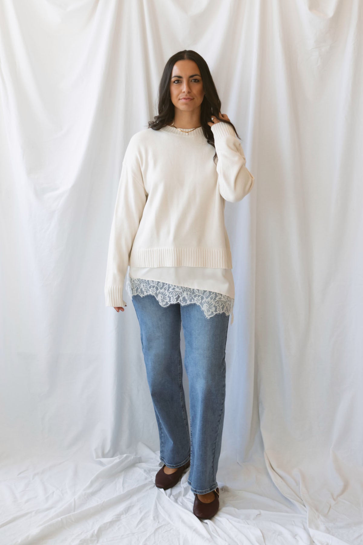 Traci cream knit long sleeve sweater top with a contrasting satin lace layered hem.