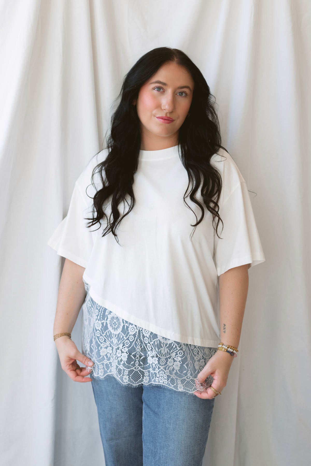 Jane ivory T-shirt featuring delicate floral lace trim and an asymmetrical design.