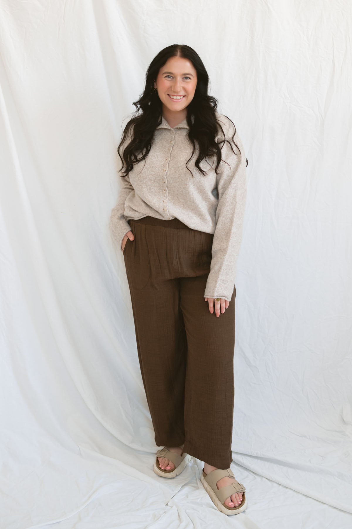 Model wearing full button up mock neck cardigan in oat.