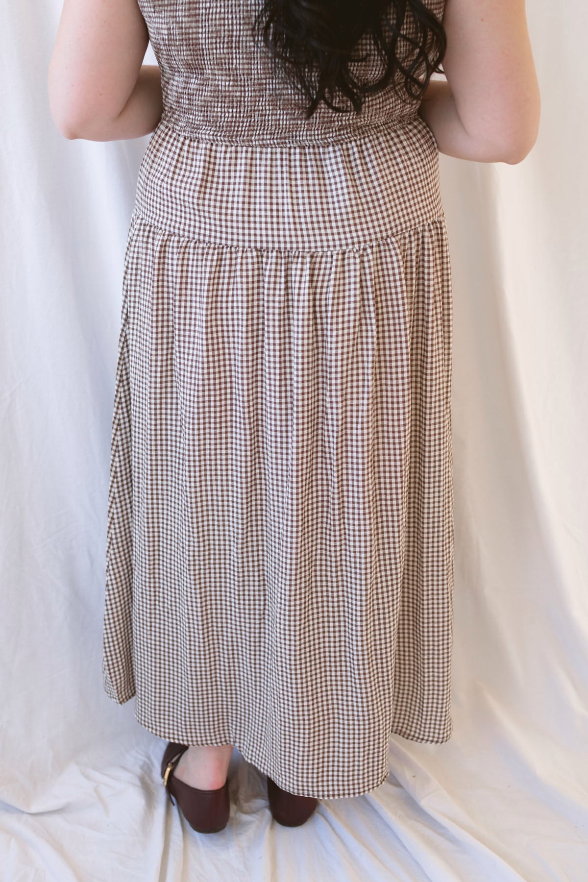 Willow brown gingham sleeveless midi dress with a smocked bodice and tiered skirt.