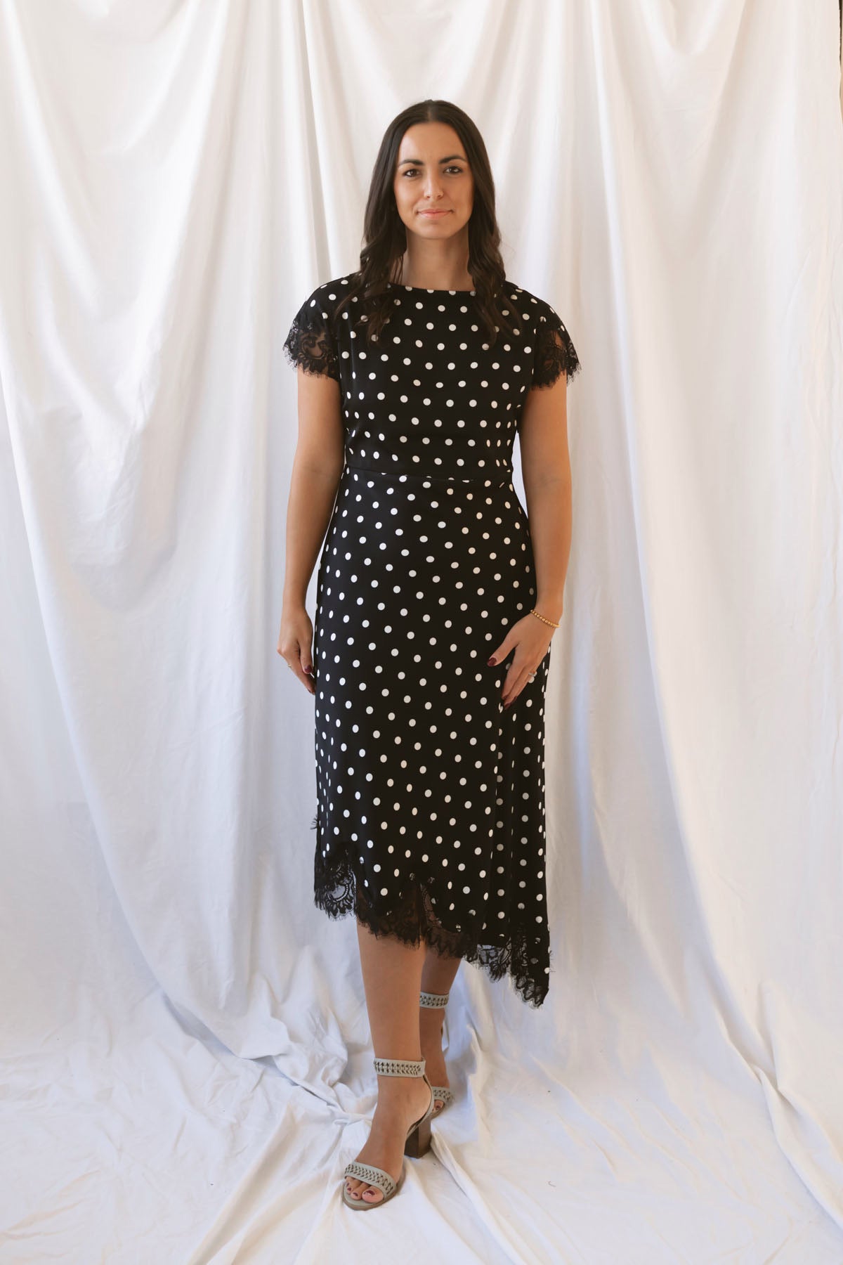 Joanna black polka dot midi dress featuring short sleeves and delicate lace trim detailing.