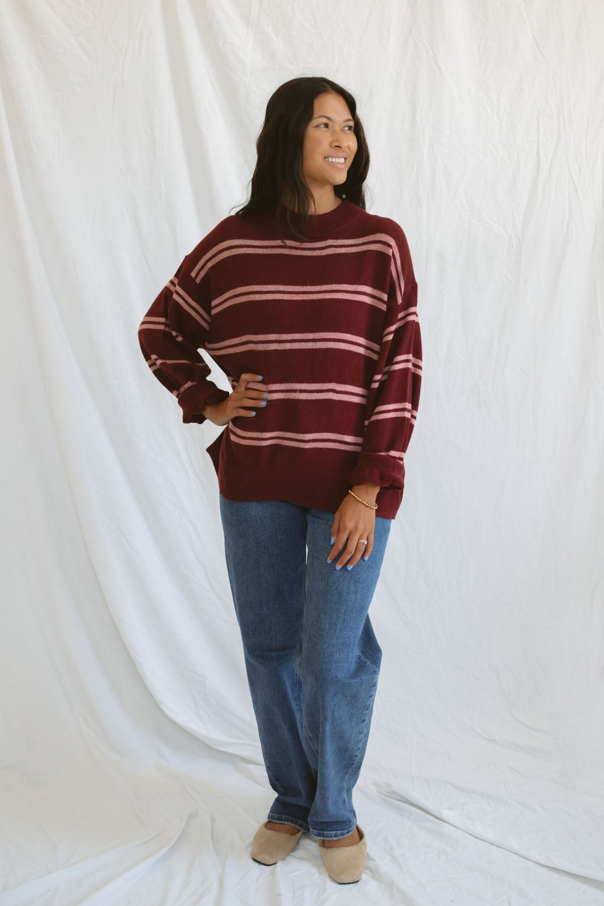 Model wearing an oversized stripe long sleeve sweater.