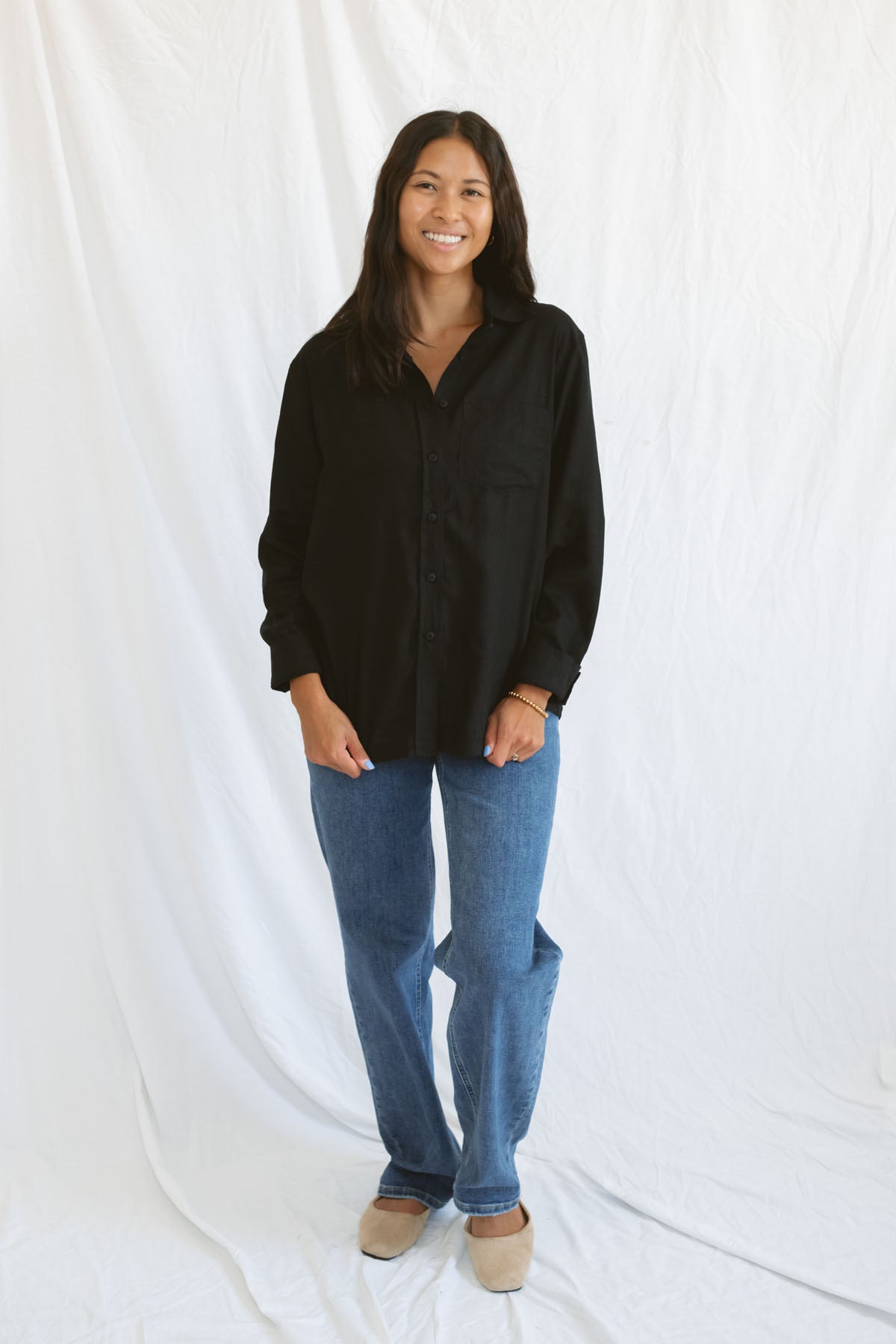 Model wearing classic black button up styled fully buttoned with a classic denim.