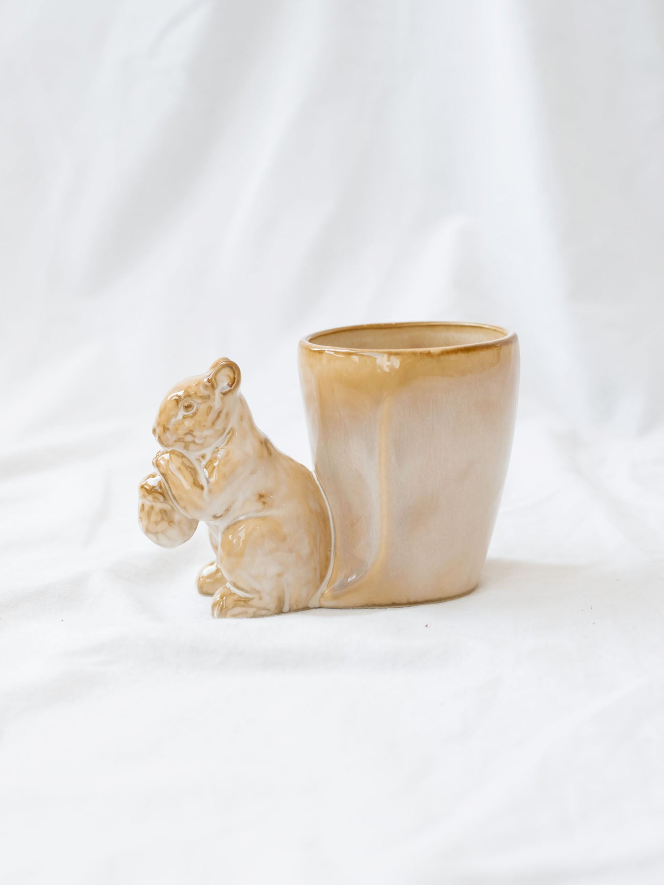 Squirrel detail mug/vase sitting on white linen backdrop.