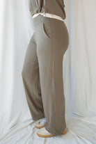 Side Picture of Woman wearing truffle high-waisted wide-leg pants with deep side pockets and a matching cropped jacket.