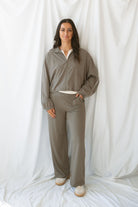 Woman wearing truffle high-waisted wide-leg pants with deep side pockets and a matching cropped jacket.