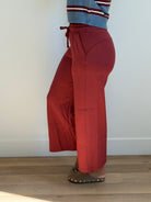 Model is wearing the butter soft drawstring waist cropped pants in merlot. 
