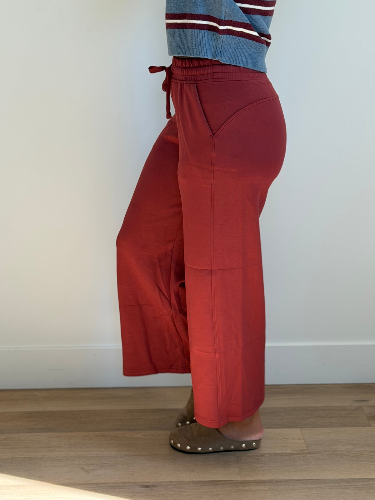 Model is wearing the butter soft drawstring waist cropped pants in merlot. 