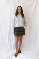 Kendra Brushed Plaid Mini Skirt in chocolate brown and olive featuring a classic plaid pattern and soft brushed texture.