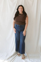 Model wearing the asymmetrical knit sweater sleeveless top with a dark pair of denim for a late summer early fall transition outfit. 